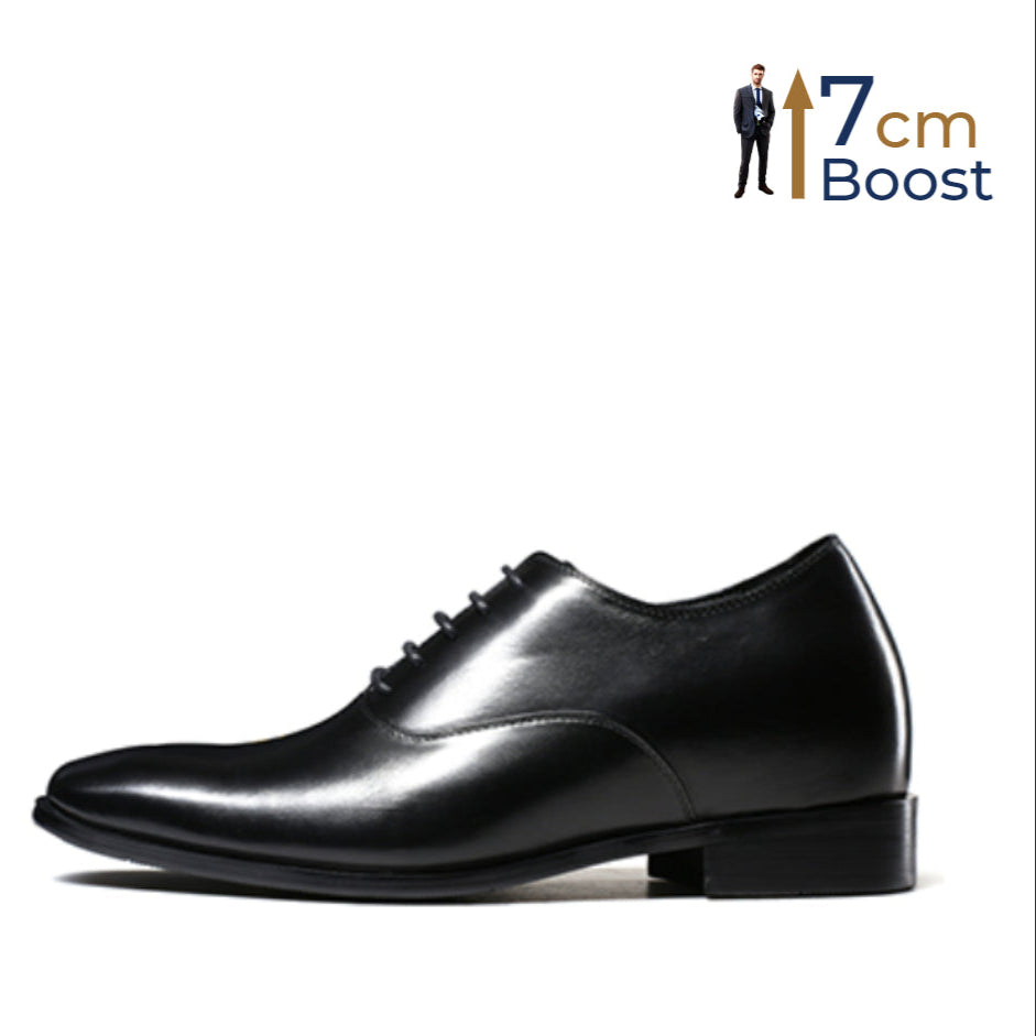 A black, sleek, lace-up dress shoe with a subtle lift, designed for a taller appearance.