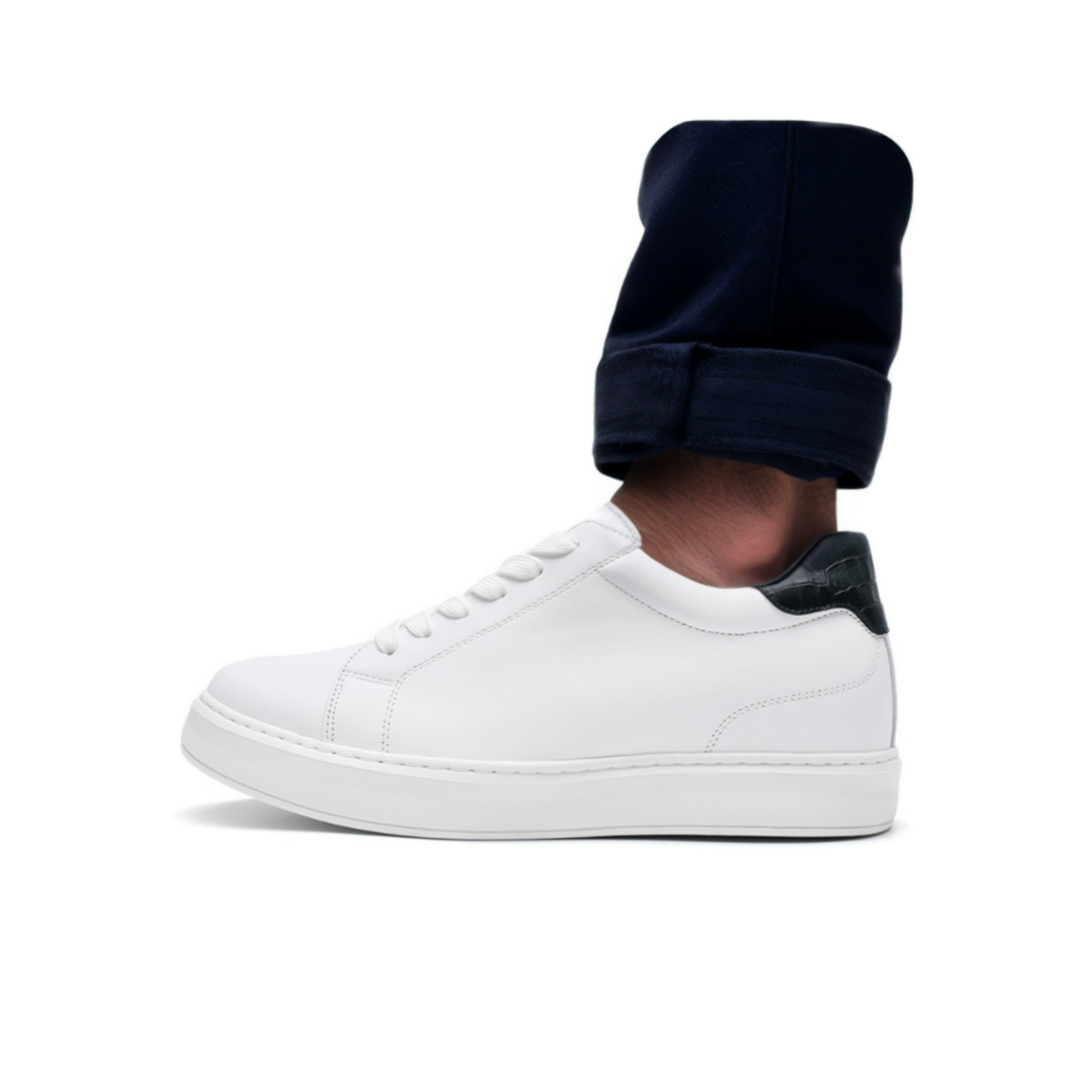 White sneaker worn with a navy sock on a white background