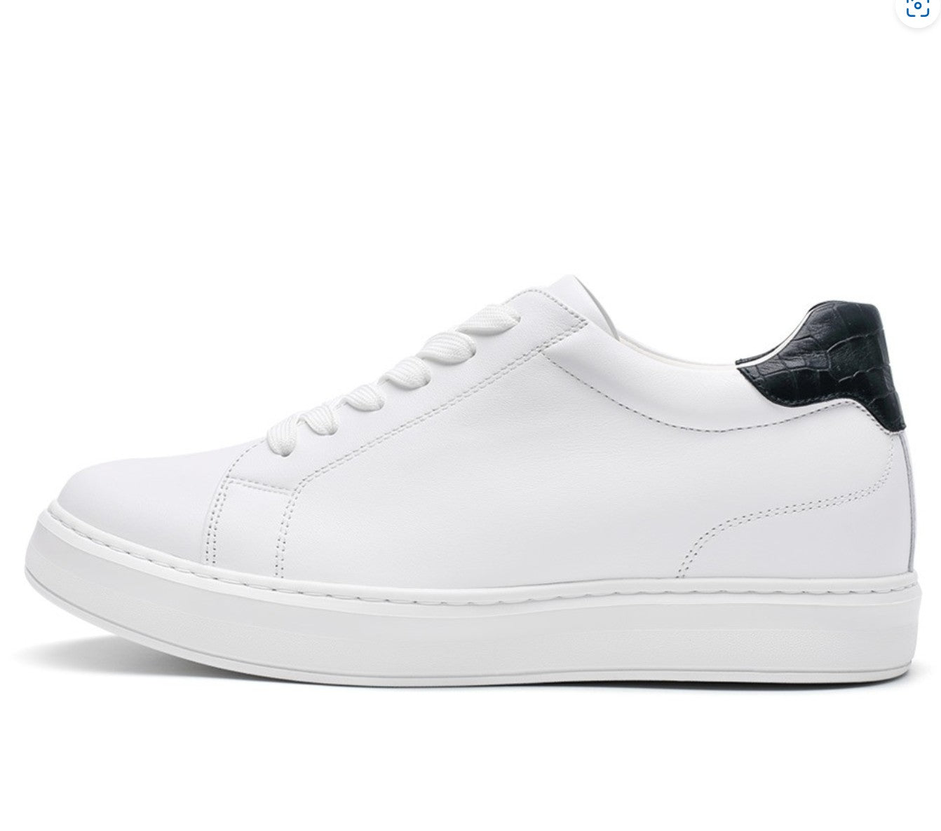 A white casual sneaker with lace-up closure, featuring a black detail on the heel and a flat sole.